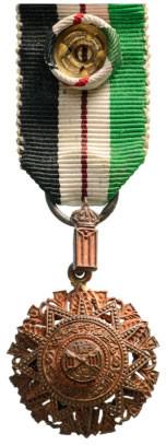 ORDER OF THE RENAISSANCE (ORDER OF AL NAHDA) NATIONAL: Officer's Cross Miniature, 4 th Class, instituted in 1917. Breast Badge, 30x18 mm, Bronze, original suspension device and original ring and ribbon with rosette. Interesting non enameled prototype! RR!