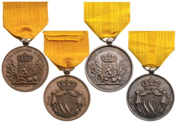 Lot of 2 Long Service Medals: Silver and bronze Classes. Breast Badges, 35 mm, Silver and Bronze, original suspension rings and ribbons. Bronze model signed "I.P. Schouberg". (2) I Country: NETHERLANDS