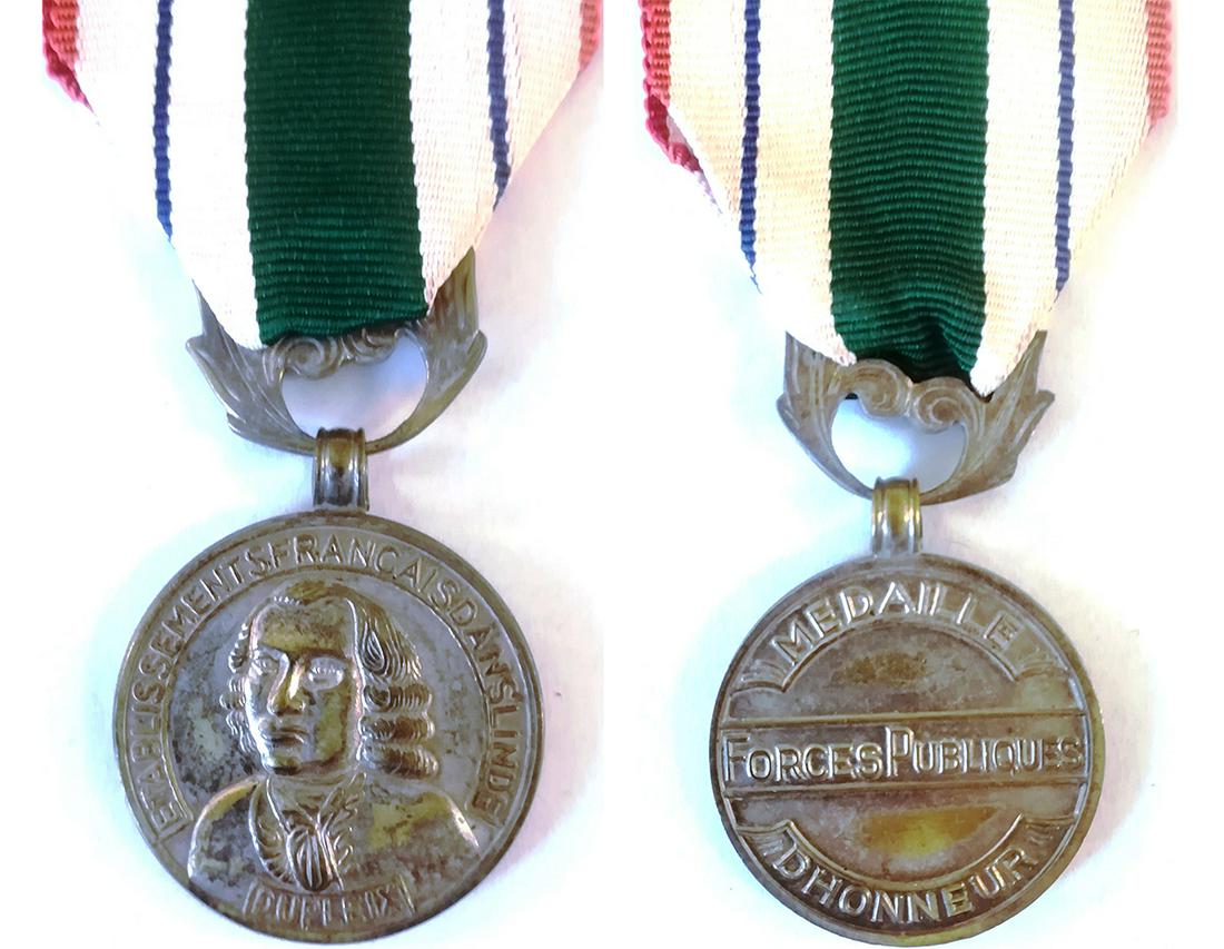 Honor Medal of Indian Public Forces, Etat Francais (so: Breast Badge, 30 mm, silvered Metal, original ornamented suspension ring and ribbon. Rare and in extremely fine condition! R! I Country: FRANCE