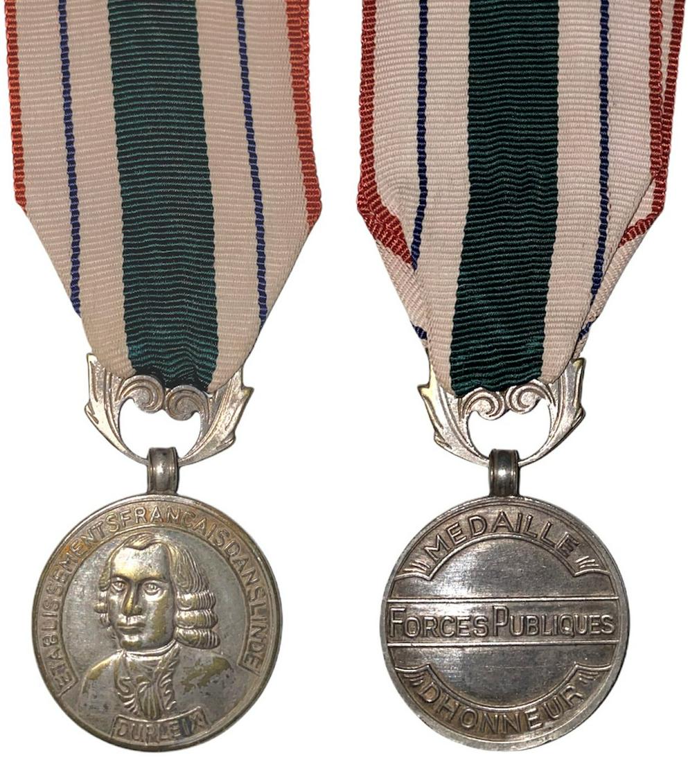 Honor Medal of Indian Public Forces, Etat Francais (so: Breast Badge, 30 mm, silvered Metal, with original ornamented suspension ring and ribbon. Rare and in extremely fine condition! R! I