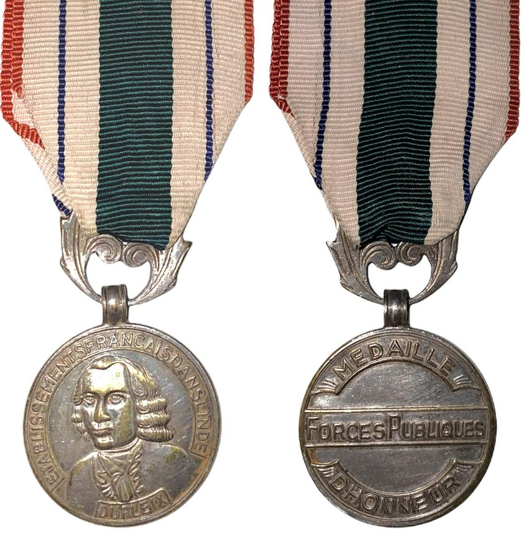 Honor Medal of Indian Public Forces, Etat Francais (so: Breast Badge, 30 mm, silvered Metal, with original ornamented suspension ring and ribbon. Rare and in extremely fine condition! R! I
