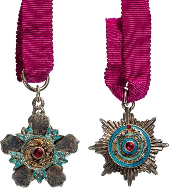 The Order of the Double Dragon: Miniature group to the 2nd Class, 1st Grade. Breast Badge, 19 x 17 mm., Silver, as a flower of five petals, flanked by blue enameled ornaments, blue- bordered, golden centre embossed with the two faci