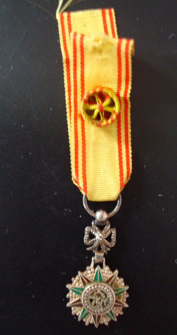ORDER OF NICHAN IFTIKAR: Country: TUNISIA Miniature Officer's Badge. Breast Badge silvered metal enamelled diamond cut rays ornamented suspension device original ribbon with rosette. Comes with lapel hole rosette.
