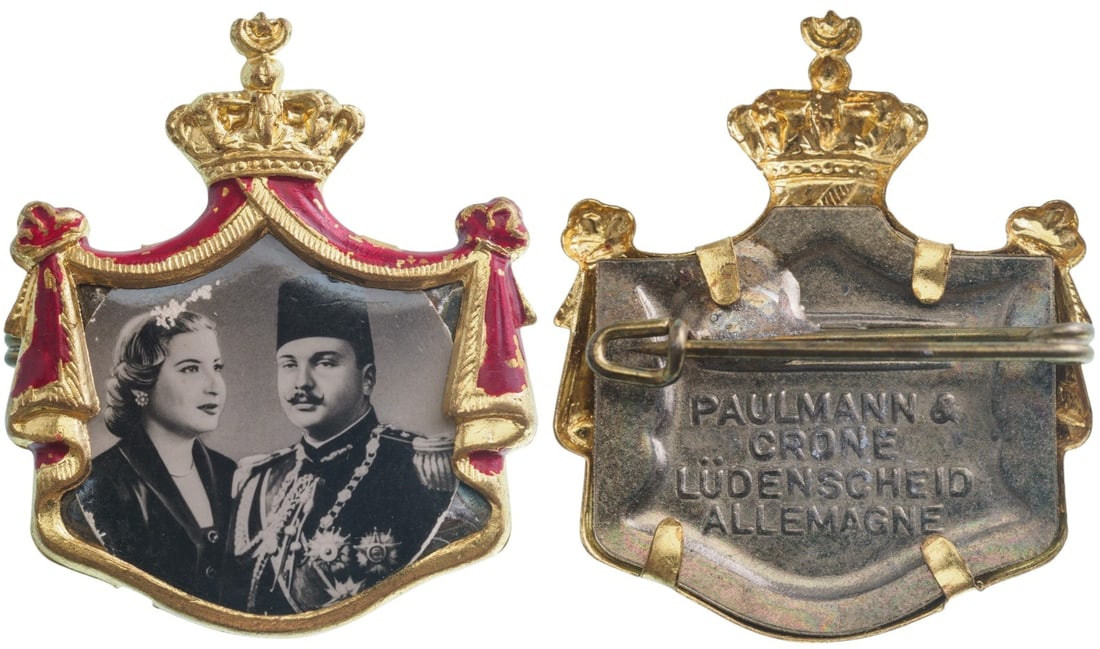 Royal Mariage Badge of King Farouk and Queen Farida, 20th of January 1938: Breast Badge, 41x31 mm., gilt Brass, obverse enameled, maker's mark "PAULMANN & CRONE, LUDENSCHEID - ALLEMAGNE", original pin on reverse. A very rare and attractive badge, of best German jeweler's qua