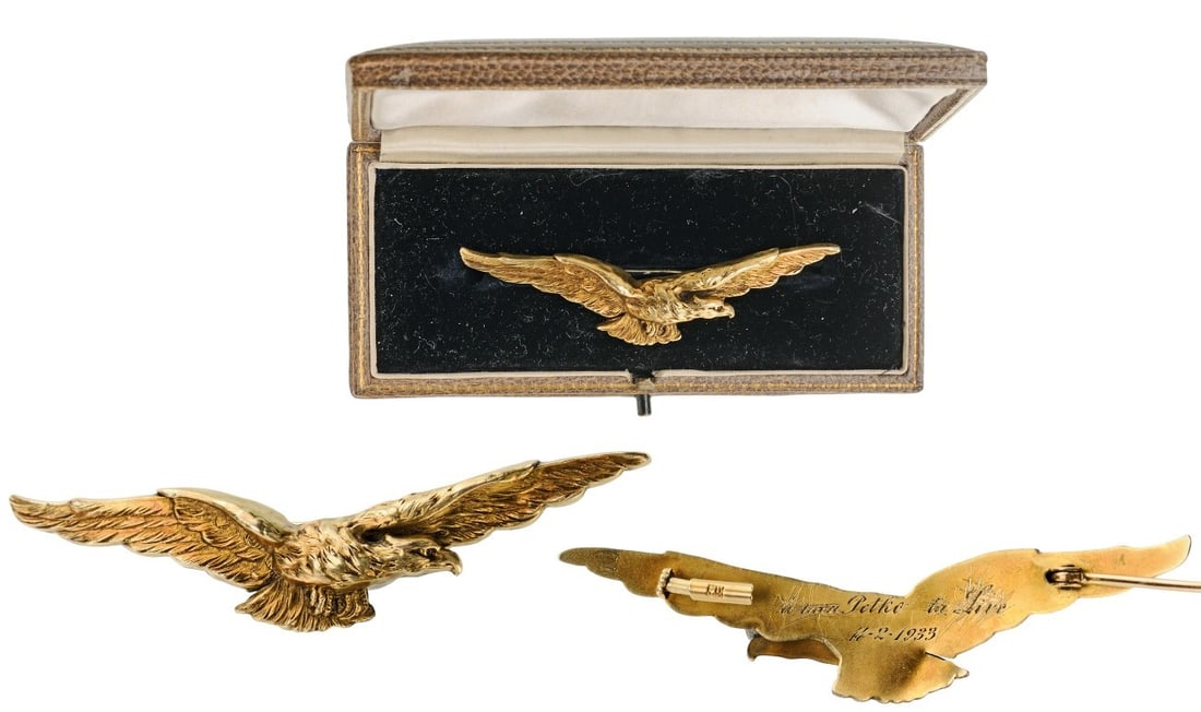 An early, WWI Bulgarian Pilot’s Badge in Gold: Based on the Italian badge’s design, with flying eagle facing right, made of Gold with chiseled details, inscription on reverse, smooth reverse with horizontal pin; in the original, beige morocco ca