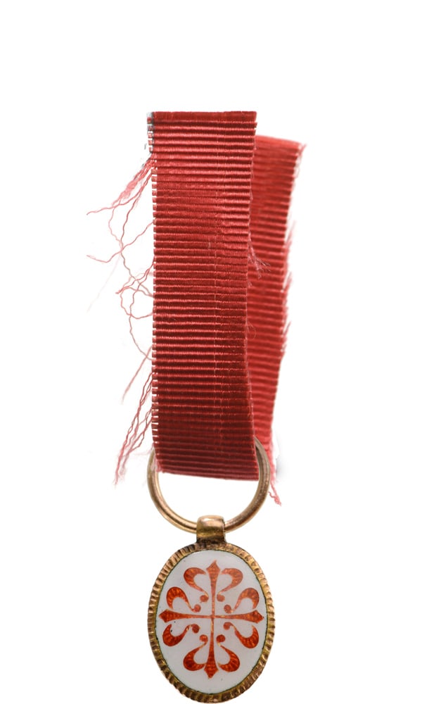 Order of Calatrava: A miniature of the Order in Gold, of oval form, white enameled, obverse bearing the Order’s cross of translucent, red enamel, chiseled, golden border; concave, polished border; with cylindical suspe