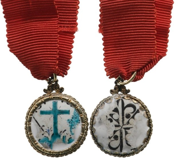 A Judge’s Badge of the Holy Inquisition: White enameled, circular medallion bearing the symbols of the Cross flanked by the sword and the green enameled olive branch; the reverse, bearing the black-and-white enameled cross of the Dominican O