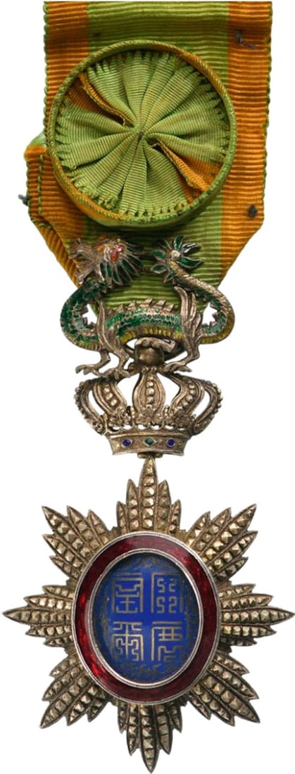 ORDER OF THE DRAGON OF ANNAM: Officer`s Cross, 4th Class, instituted in 1886. Breast Badge, 86x47 mm., gilt Silver, brilliant cut rays, central medallion enameled, original suspension device, ring and ribbon with rosette. A superb
