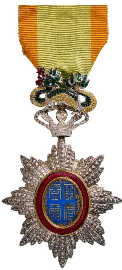ORDER OF THE DRAGON OF ANNAM: Knight's Cross, 5th Class, instituted in 1886. Breast Badge, 85x51 mm., Silver, brilliant cut rays, central medallion enameled, original suspension device, ring and ribbon. An extremely fine badge, in
