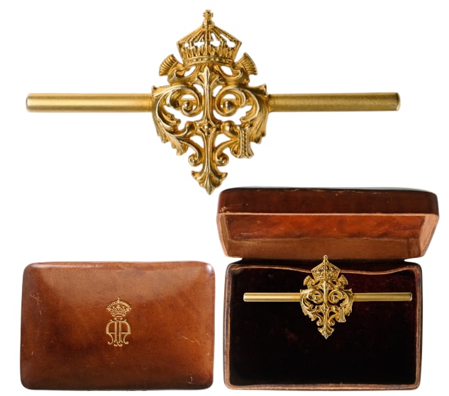 Brooch with the Royal Cypher of Tsar Ferdinand I: An elaboralely-made monogram of the sovereign, 24x12,8 mm., GOLD, mounted to a horizontal, smooth golden bar with thin, round pin; in its original, brown morocco case of issue, its lid, embossed with 