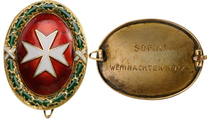 Gold Badge with the Cross of Malta: Breast Badge, 25x16,65 mm., Gold, with white enameled Maltese cross on oval, convex, red enameled field, within green enameled oak wreath tied by white enameled ribands, the reverse, fitted with verti