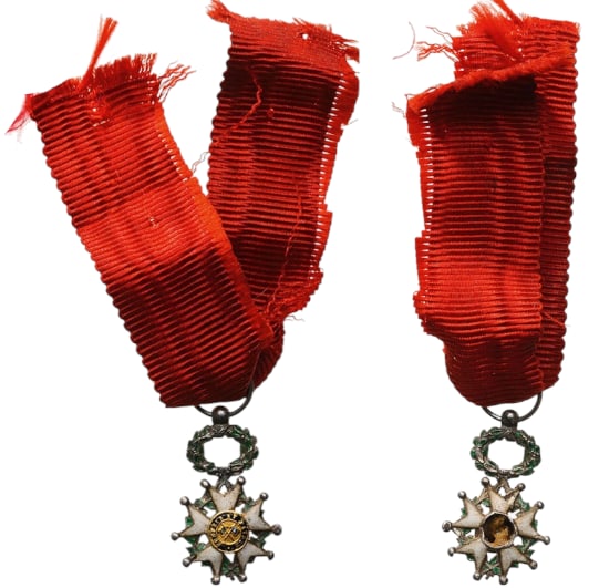ORDER OF THE LEGION OF HONOR: Knight`s Cross Miniature, 3rd Republic, 5th Class. Breast Badge, Silver, both sides enameled, obverse center missing, central medallion gold, enameled, original suspension ring and ribbon. IV