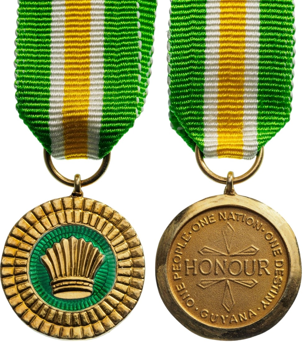 Order of Service of Guyana, The Cacique`s Crown of Valour, instituted in 1970: Breast Badge Miniature, 18x20 mm, gilt Metal, one side enameled, original suspension ring and ribbon. Rare and very elegant! I R!