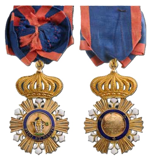 Order of St. Ferdinand and of the Merit: Knight’s Badge. Breast Badge, 62.5x39 mm., GOLD, six groups of three polished beams each, flanked by 6 white enameled fleurs de lys; polychrome enameled image of St. Ferdinand with armour and robes 