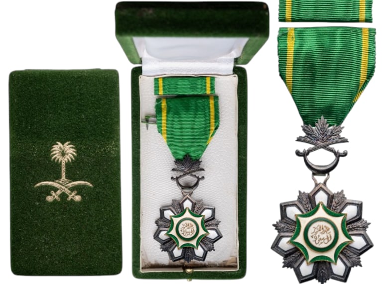 Order of Abdul Aziz, 1st Type, 1964: Knight's Cross, instituted in 1964. Breast Badge, 66x40 mm, Silver, one-side enameled, original suspension palms, ring and ribbon, in case of issue with gilt weapon on the lid, together with lapel bar