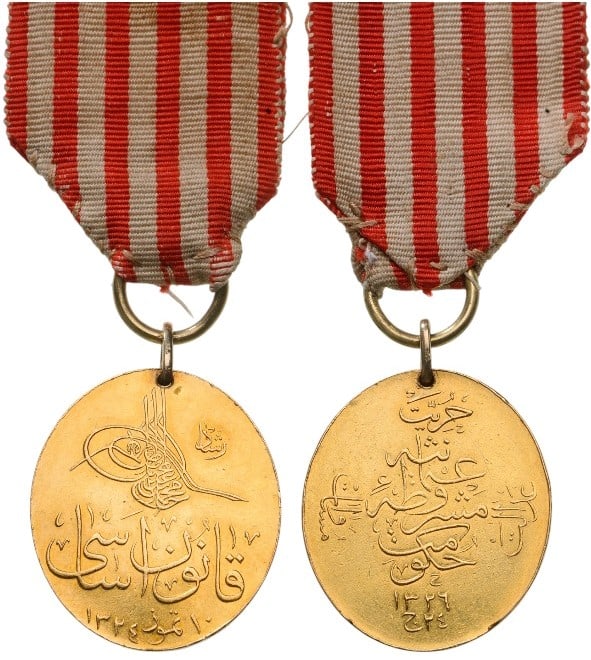 The Medal of the Constitution (Kânûn-? Esâsî Madalyas?): Oval GOLD Medal, 28 x 27 mm., the obverse with Tughra of Sultan Mehmet V Read and the inscription “Constitution, July 10th, 1324” (July 23rd, 1908) in Arabic calligraphy, the reverse with the 