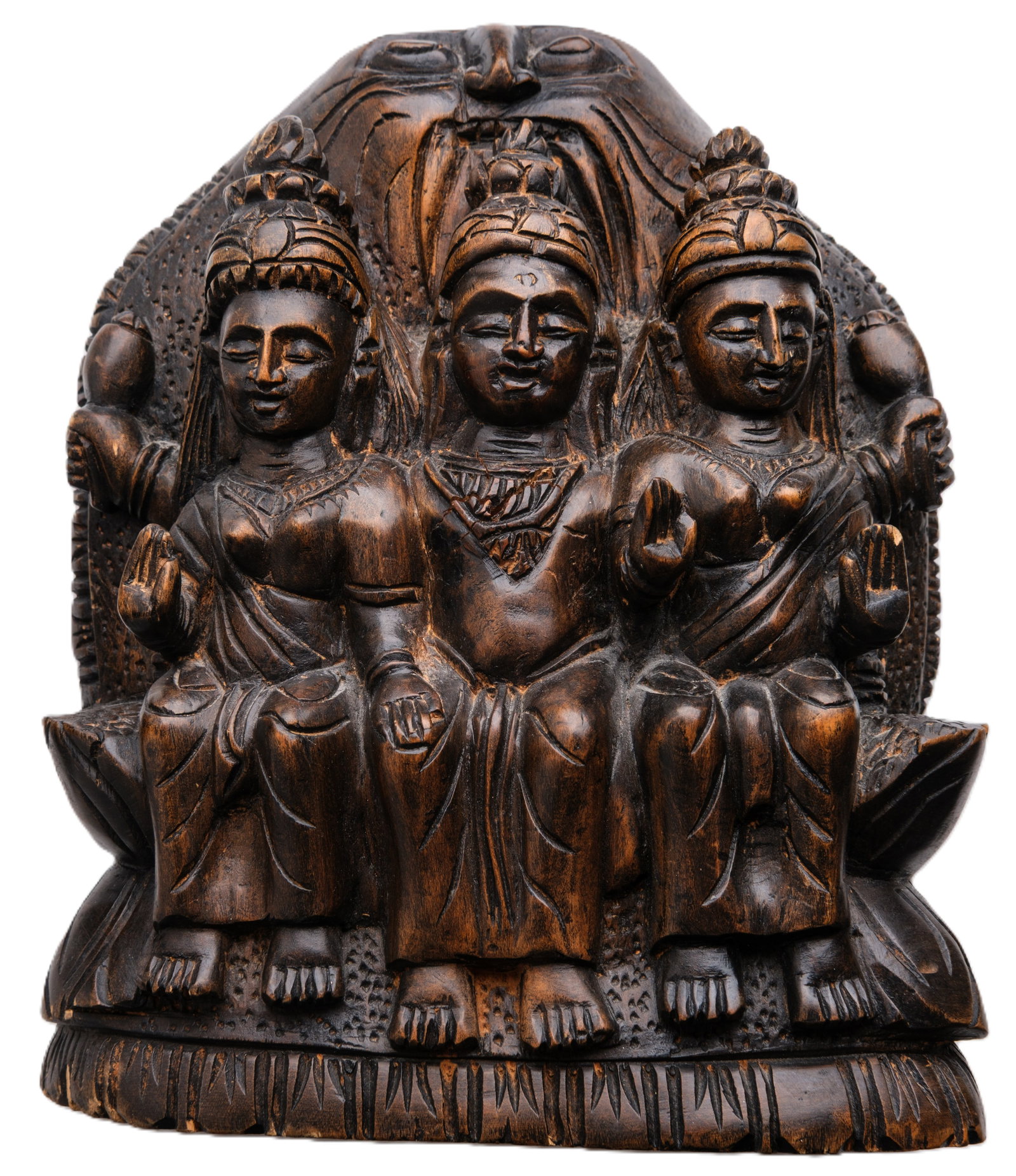 High-relief Sculpture depicting Three Deities: High-relief sculpture in dark patinated wood, depicting three draped and ornately coiffed deities (two female figures flanking one male figure), holding ritual instruments. A naive, votive work from