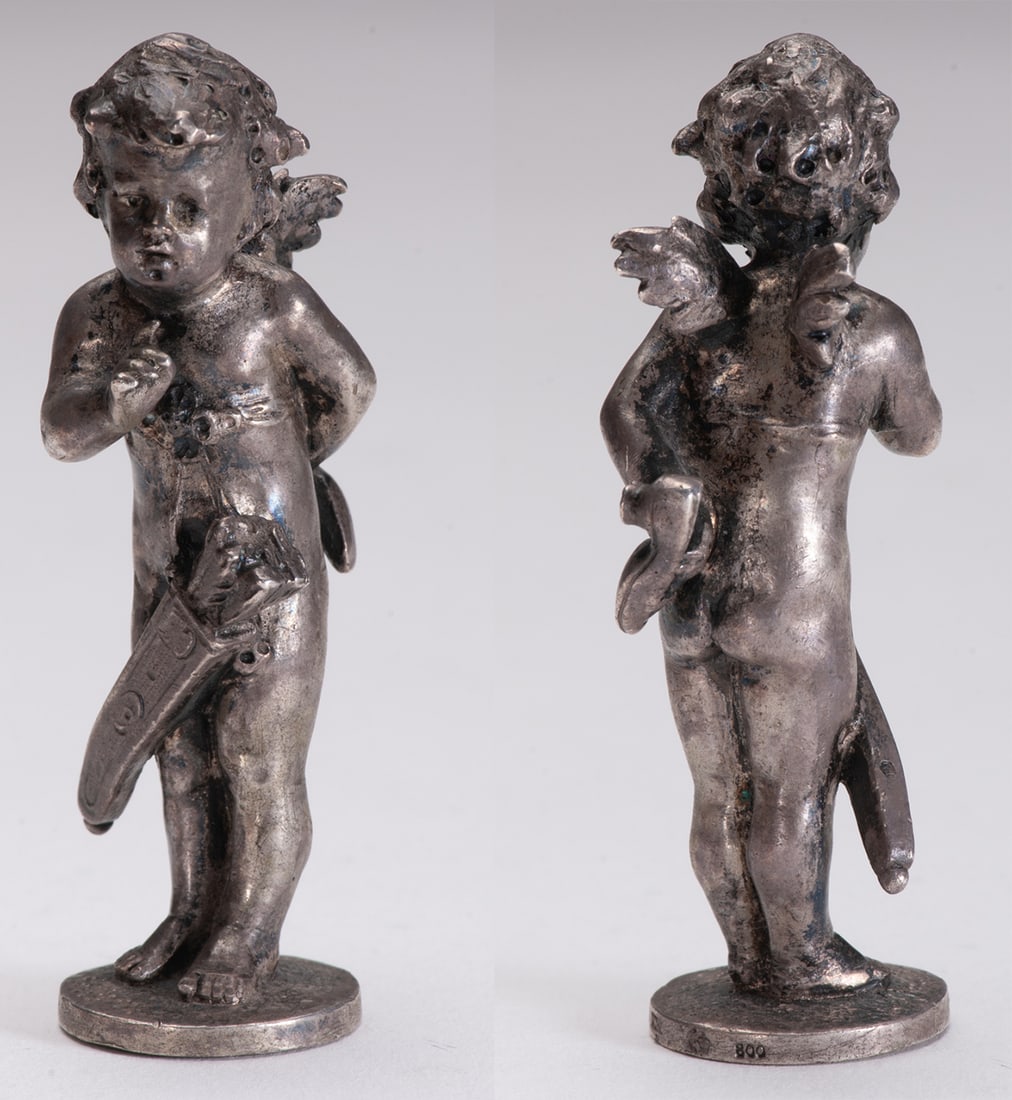 Silver bottle stopper about Cupid concealing a woman's shoe on her back: Weight 69 g, height 78 mm. Germany late nineteenth century, guarantee 800, silversmith "K.W" unidentified. Good condition