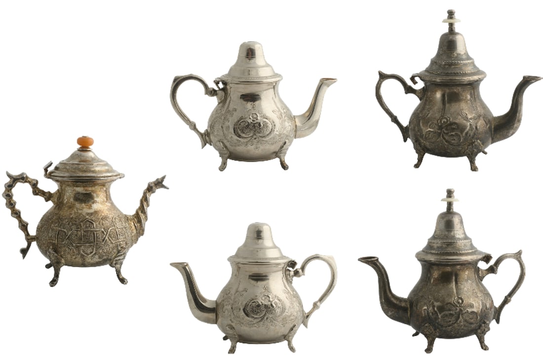 Beautiful lot consisting of three quality teapots in silvered metal: 1.baluster-shaped model on four feet with folding lid, pot-bellied, large recto-verso engraved decoration with double medallion and volutes (probably a wedding gift), height 18 cm at the seed. Good