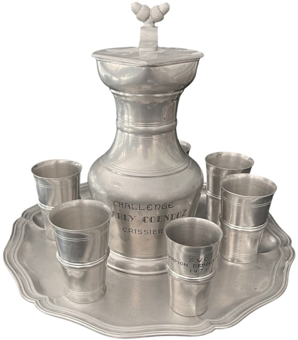 Set of 7 - Jug, Cups and Tray, Swiss Shooting Prize: Set of 7 elements comprising: 1. Tin water or milk jug with decorated handle, incribed "Challenge Charly Coendoz, Crissier" and the names of the contestants. Dim.: 19,5 x 12 cm. 2. Set of 5 tin