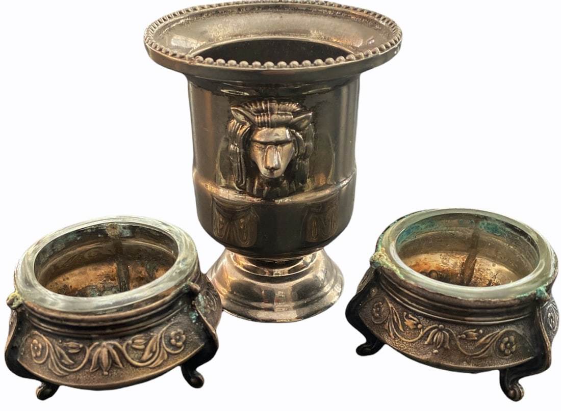 Lot of 3 Table Elements: Lot composed of three table elements in silvered metal: 1. pair of round tripod salt shakers in the shape of a basin, neo-antique model decorated with a plant frieze around the border, glass interiors