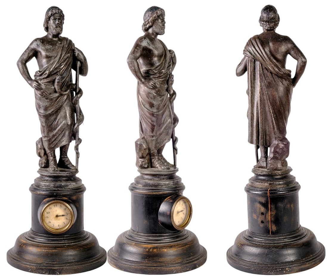 Hippocrates Mantel Clock: Large bronze mantel clock with dark patina about the great Hippocrates at full length, draped in an ancient toga, supported by the serpent caduceus symbol of medicine and pharmacy. Blackened turned wo