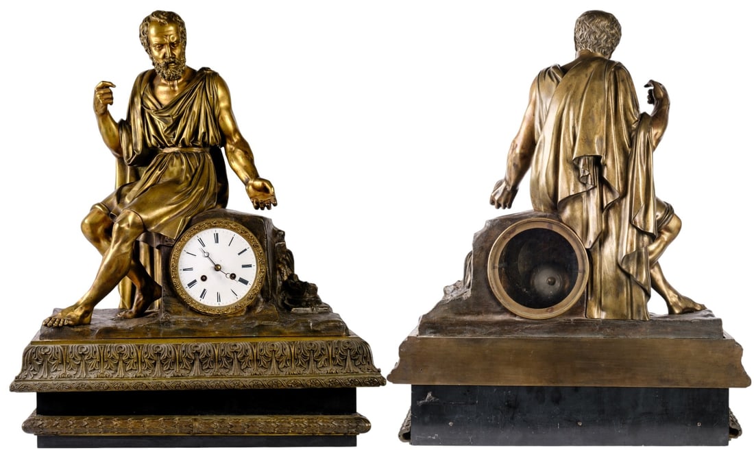 Aristotle Mantel Clock: Important bronze mantel clock with golden patina, representing Aristotle the stagirite seated draped, the wooden base richly engraved on the front with foliage. The enameled dial with Roman numerals. 