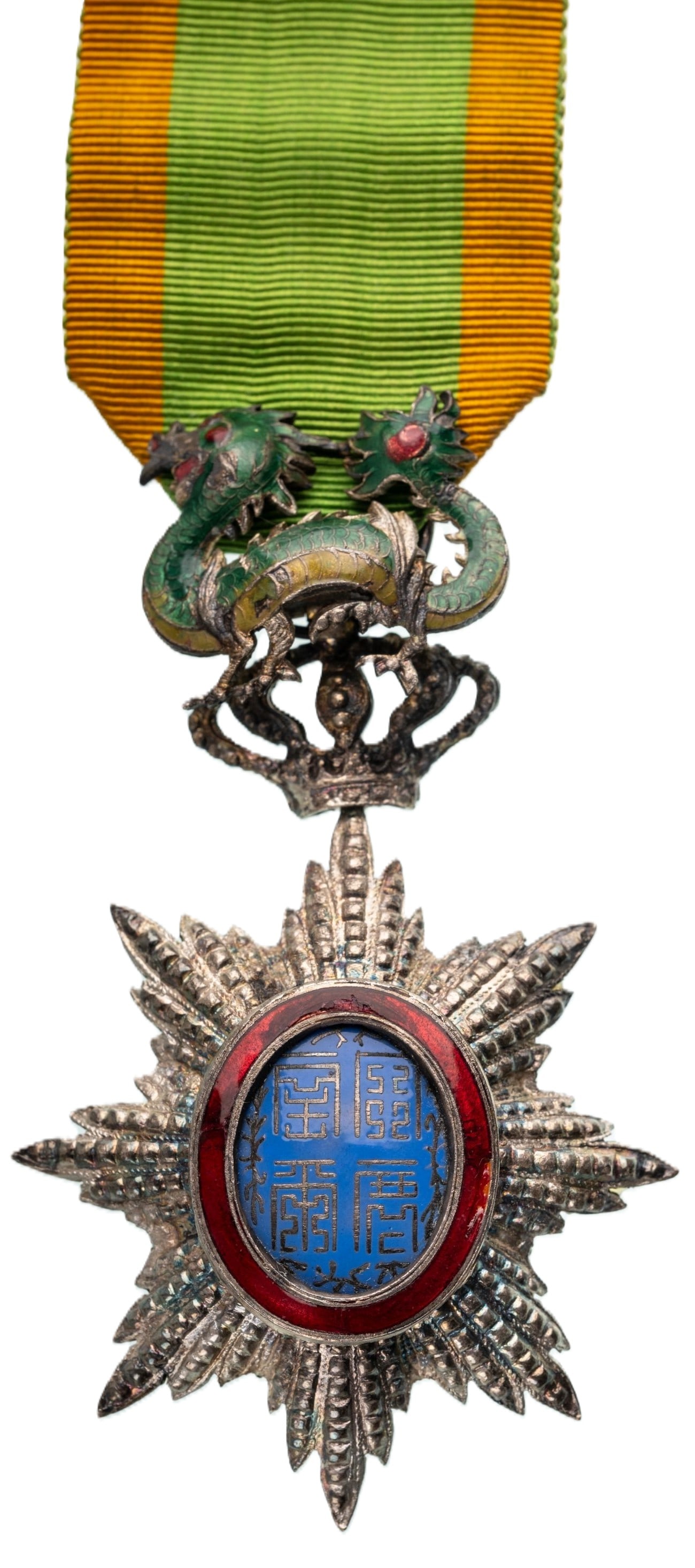 ORDER OF THE DRAGON OF ANNAM: Knight's Cross, 5th Class, instituted in 1886. Breast Badge, 85x51 mm., Silver, brilliant cut rays, central medallion enameled, original suspension device, ring and ribbon. An extremely fine badge, in
