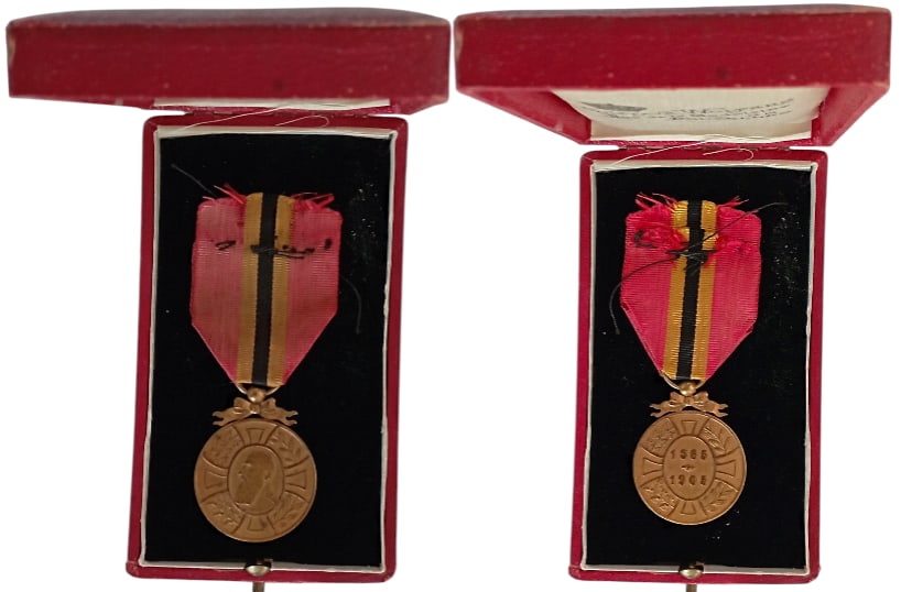 King Leopold II 40 Year Commemorative Medal, 1909: Breast Badge, 39x31 mm, Bronze, original suspension ring and ribbon, in case of issue by "Gustave Wolfers, Bruxelles" with gilt weapon on the lid. Extremely fine! I