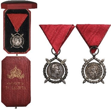 Order of Merit, Prince Ferdinand I issue, 3rd Model: 3rd Type, 2nd Class, Prince Ferdinand I emission. Breast Badge, 42x32 mm, Silver, original suspension ring and triangular ribbon, in case of issue, with gilt crown and inscription on the lid. Extremel