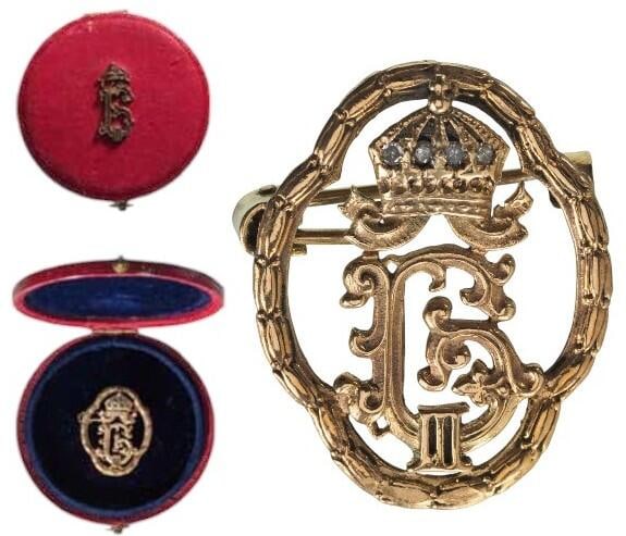 Royal Familyâ??s Honour Giftfrom Tsar Boris III: Breast Badge, 30 x 23 mm., GOLD, as an ornamented crowned, cyrillic Royal monogram, the crown, elegantly set with tiny Diamonds, enclosed within a finely embossed laurel wreath, the reverse, fitted wi