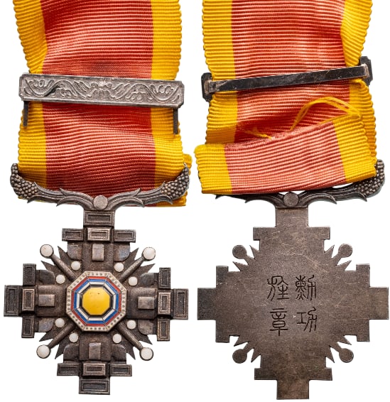 The Order Of The Pillars Of The State: 6th Class, Instituted 1934 by Emperor Kang Teh. Breast Badge, 44x40 mm., Siver, four stylized pillars in dark patina meeting at the centre, the quadrants featuring four diagonal lines ending in enamel