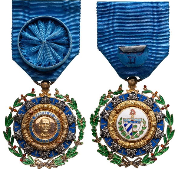 Order Of Carlos Manuel De Cespedes: Knight's Cross, 5th Class, instituted in 1926. Breast Badge, 48x43 mm., gilt Silver, enameled, central medallion gilt, enameled, original suspension ring and ribbon with rosette. Extremely fine condit
