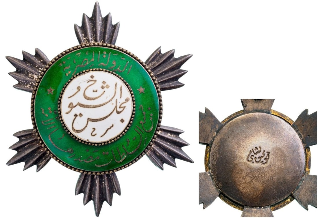 Badge of Members to The Royal Senate: Breast Badge, 62 mm., Silver, as a roughly round star of polished rays, large, white enameled centre medallion with long, calligraphic inscription, within green enameled outer circlet, also bearing a