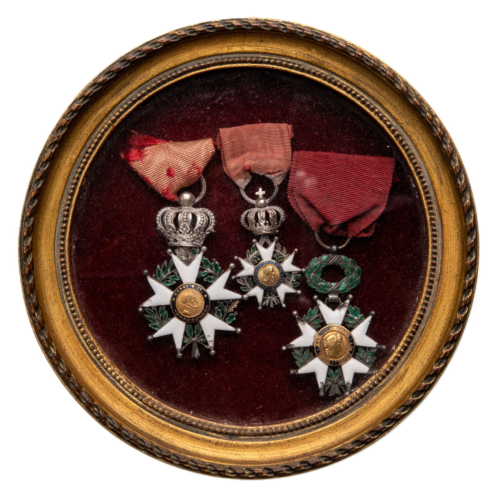 ORDER OF THE LEGION OF HONOR: Framed group of 3. Knight`s Cross, Louis Philippe King Period (1830-1848), 5th Class, instituted in 1802. Breast Badges, 60x38 and 42x23 mm, Silver, enameled (damages), central medallions GOLD, enamel