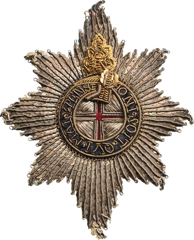 The Most Noble Order of the Garter: An early, embroidered Breast Star, 125x104 mm. The rays of silver wire and sequines, the centre with thin, red woollen cross within thick silver embroidery, the outer circlet made as a tied garter wit