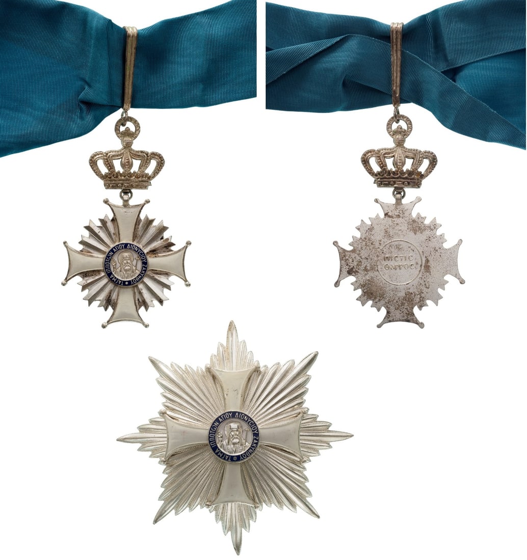 The Order of St. Denis of Zante: Grand Cross Set. Sash Badge, 90x55 mm., Silver-plated, white enameled cross with silver beams between the arms, white enameled centre medallion with the image of St. Dyonisos, blue enameled outer circ