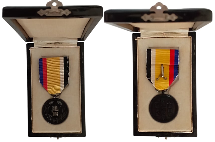 Manchukuo National Foundation Medal, instituted in 1933: Breast Badge, blackened Silver, 34x31 mm, original suspension ring and ribbon, in black laquered case of issue, with inscription on the lid. Mint state! I