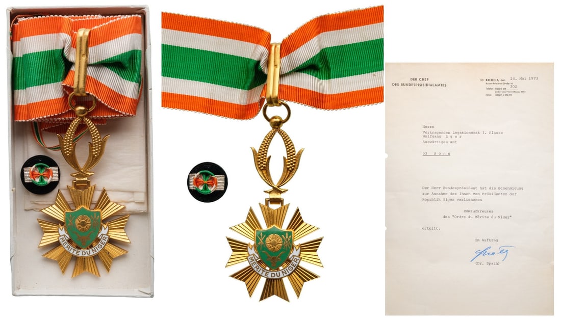 ORDER OF MERIT: Commander's Cross. Neck Badge, 73x37 mm., gilt Bronze, one-side enameled, original suspension wreath, loop and ribbon, in case of issue with lapel hole rosette, together with awarding document to a Ge