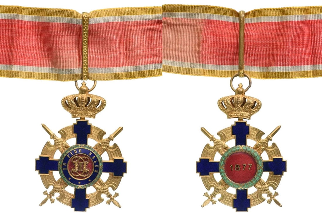 ORDER OF THE STAR OF ROMANIA, 1864: Commander`s Cross, 2nd Model (1938), for Military. Neck Badge, 71x50 mm in gilt Bronze, enameled, with original suspension ring, loop and ribbon. Obverse medallion with cipher of Carol I, reverse with