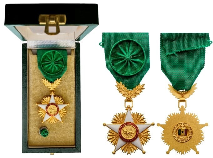 NATIONAL ORDER OF THE LION: Officer's Cross, 4th Class, instituted in 1960. Breast Badge, 55x42 mm, gilt Silver, original suspension ring and ribbon with rosette, in case of issue by "Comptoir France - Suisse, Dakar"A very attra
