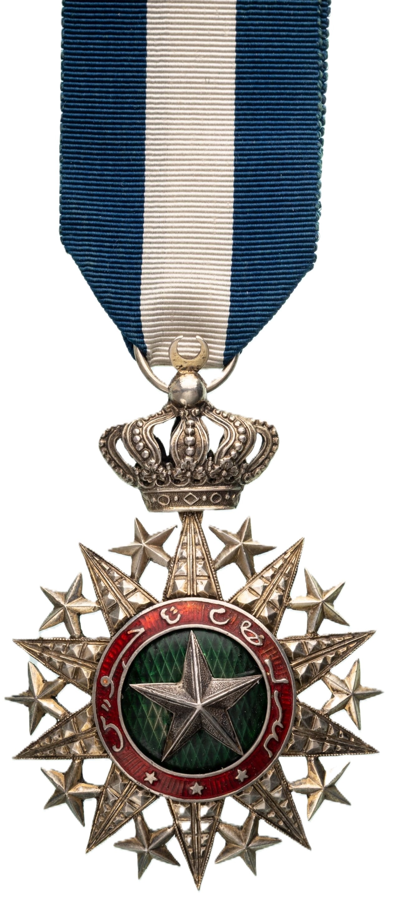 Order Nichan el Anouar (Order of the Light) INSTITUTED by Hamed ben Mohamed, Sultan of Tadjourah: Knights Cross, 5th Class, instituted in 1887. Neck Badge, 74x51 mm, Silver, center enameled, original ornamented suspension crown, ring and ribbon. A rare and attractive badge, in extremely fine