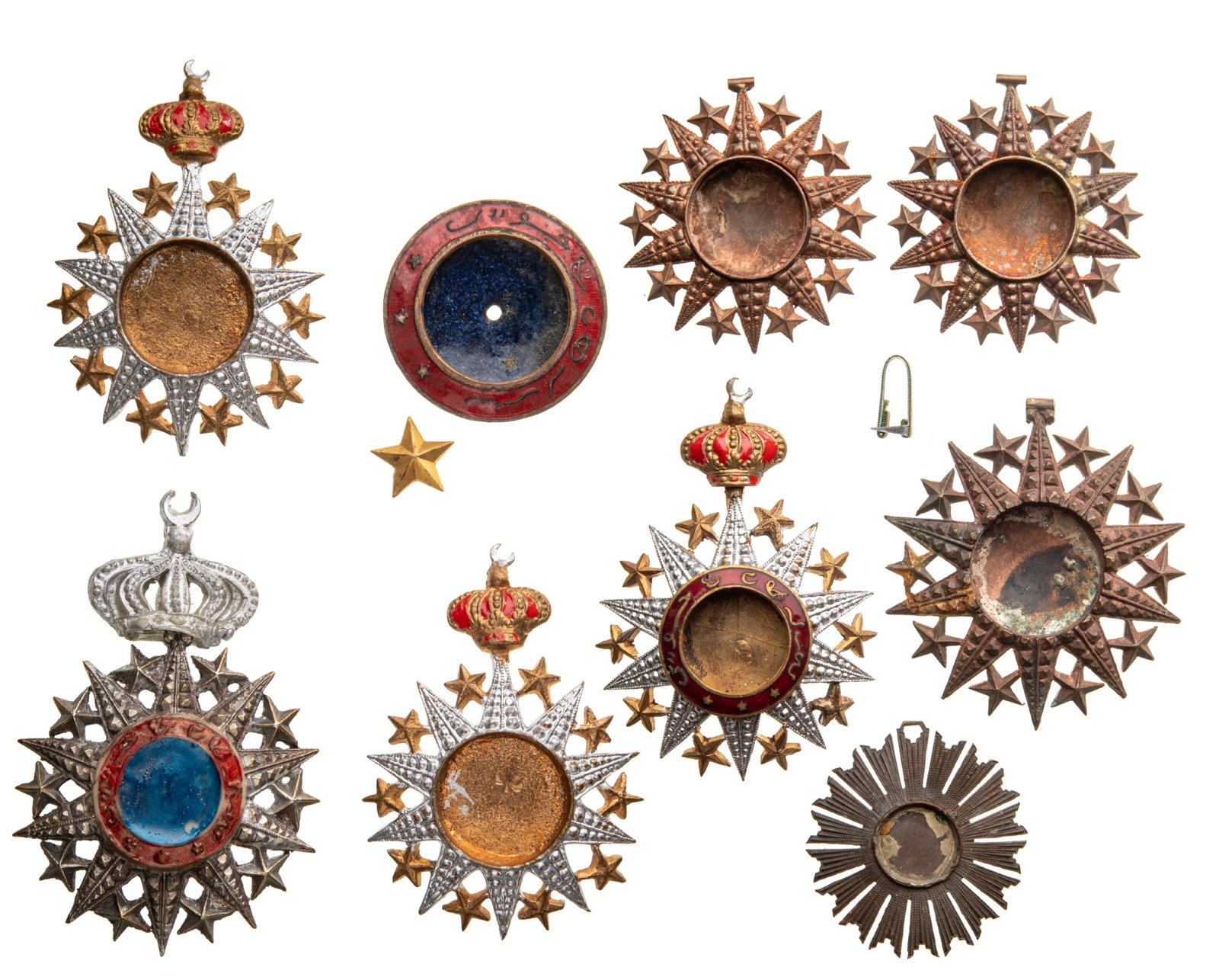 Order Nichan el Anouar (Order of the Light) INSTITUTED by Hamed ben Mohamed, Sultan of Tadjourah.: Lot of 9. Commander's and Knight's Crosses, instituted in 1887. Breast Badges, various sizes, Bronze, one enameled, 4 with original suspension crowns, together with a center, enameled for a Grand