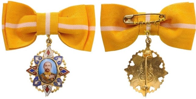 King Rama V Honour Badge: Oval portrait made in fine miniature enamel, of King Chulalongkorn in uniform, 29,5 mm., enclosed in an elaborate gilt and enameled frame, its reverse, fitted with pinback suspension, upper loop and m