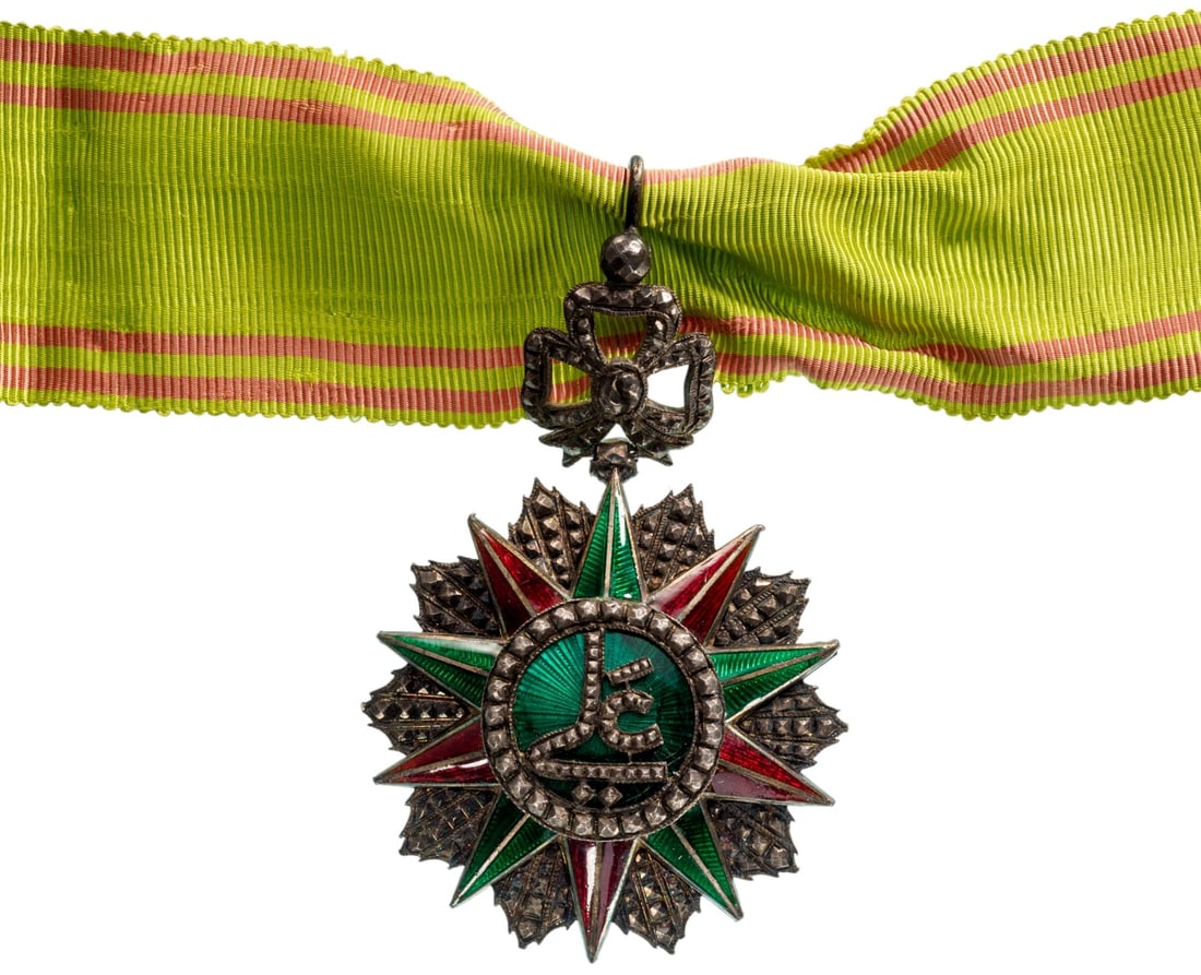 ORDER OF NICHAN AL IFTIKHAR: Commander's Cross, 3rd Class, Ali Bey (1882 - 1902). Neck Badge, 72x50 mm, silver, partially enameled, original suspension ring and ribbon with closing system. A beautiful luxury reduced size fabricat