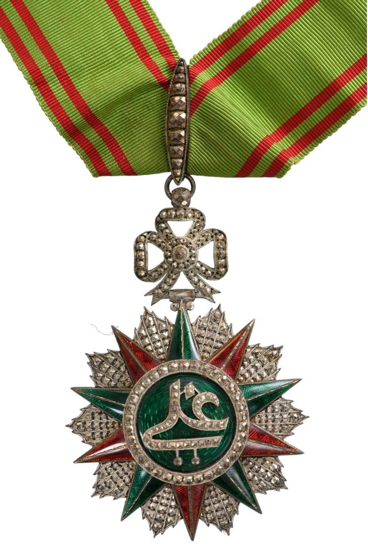 ORDER OF NICHAN AL IFTIKHAR: Commander's Cross, 3rd Class, Ali Bey (1882 - 1902). Neck Badge, 90x63 mm, Silver, partially enameled, original suspension ring and ribbon. A beautiful luxury fabrication, in mint condition. I