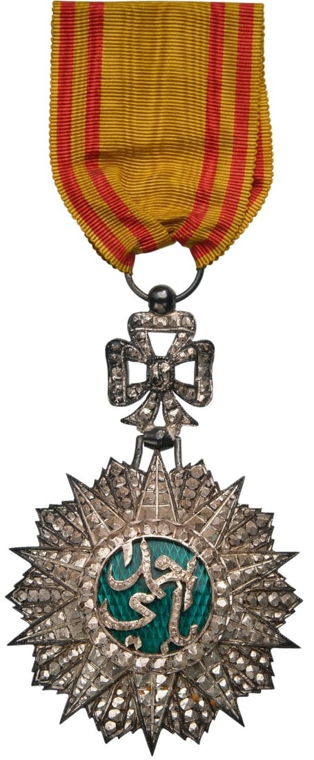 ORDER OF NICHAN AL IFTIKHAR: Knight's Cross, 5th Class, Sidi Ahmed (1929 - 1942).Breast Badge, 82x54 mm, Silver, partially enameled, original suspension ring, loop and ribbon. A beautiful luxury fabrication, extremely fine condit