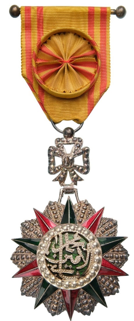 ORDER OF NICHAN AL IFTIKHAR: Officer's Cross, 4th Class, Mohahmed el Amin (1943 - 1957). Breast Badge, 79x49 mm, Silver, enameled, original suspension ring, ribbon with rosette and suspension bar. Extremely fine condition and sup