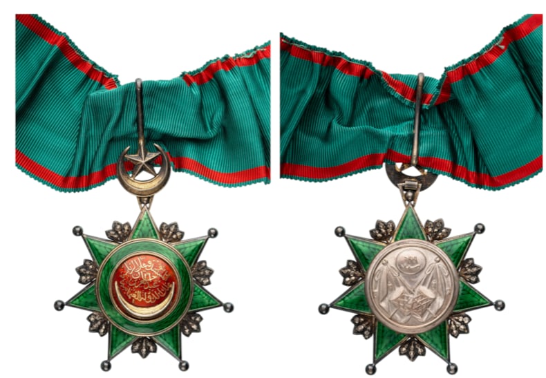 ORDER OF OSMANI: Commander's Cross, 3rd Class. Neck Badge, 79x62 mm., Silver, enameled, gold centre medallion with the Sultan`s Tughra, original suspension with crescent, star, loop and ribbon. A superb badge, in extr