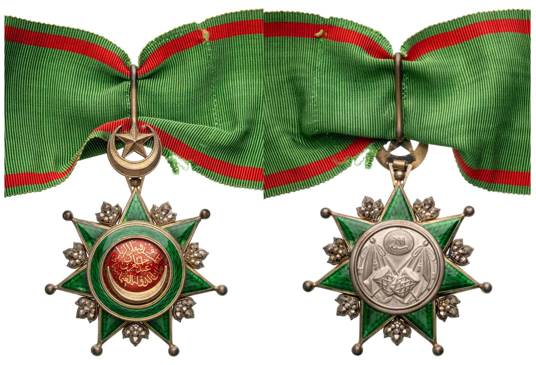 ORDER OF OSMANI: Commander's Cross, 3rd Class. Neck Badge, 81x64 mm., Silver, enameled, gold centre medallion with the Sultan`s Tughra, original suspension with crescent, star, loop and ribbon. A superb badge of large